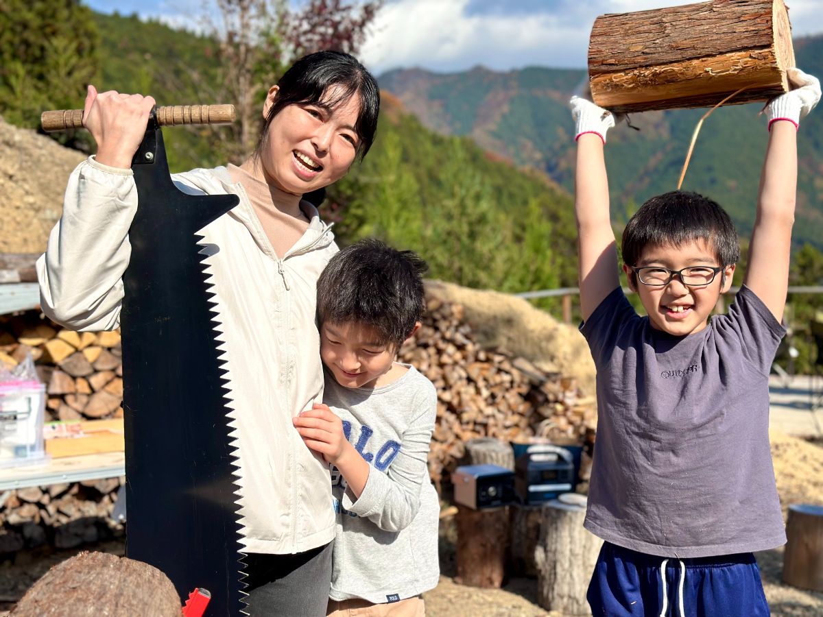 切った丸太を掲げる参加者ファミリー